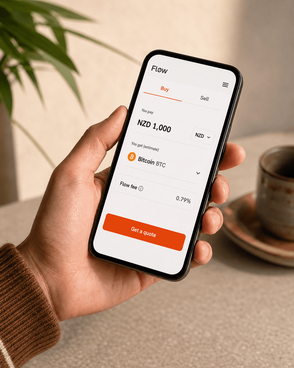 A hand holding a phone displaying the Flow Crypto Bitcoin quote screen